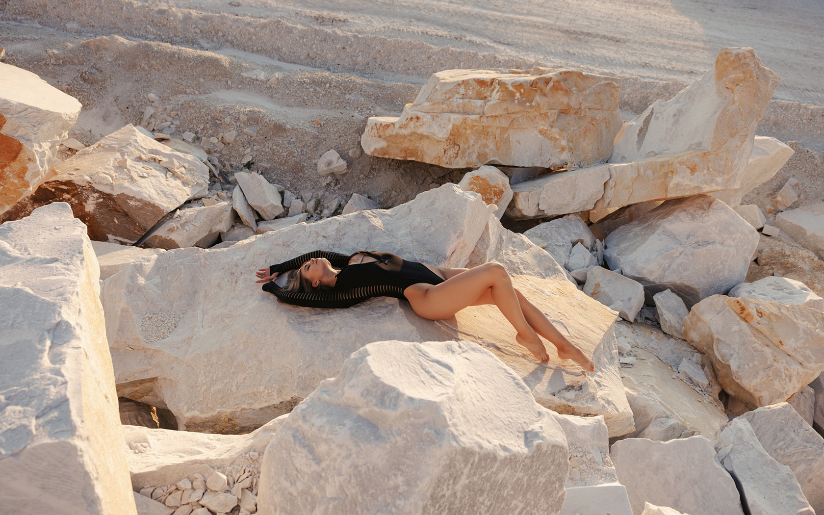 , women outdoors, hips, blonde, bodysuit, sky, clouds, rocks, model, black bodysuit, women, ass, nature, lying on back, closed eyes